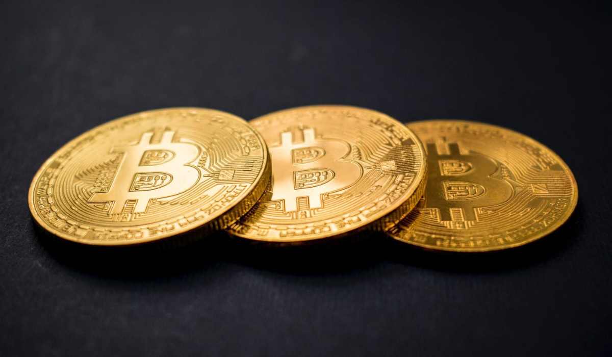 três moedas de bitcoin em um fundo preto